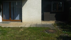 Un bâtiment moderne avec une façade en béton, de grandes portes-fenêtres coulissantes et une petite fenêtre.