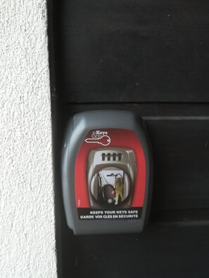 A car door lock with a red and white Key & Lock logo, a keyhole, and a warning label that says "Keeps your keys safe."
