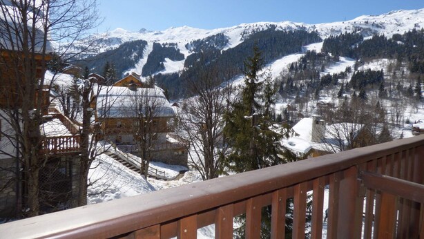 A snow-covered mountain landscape with a wooden balcony railing. - Lovely apartment in Méribel center, close to slopes, for 5 persons (Méribel)