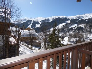 A snow-covered mountain landscape with a wooden balcony railing. - Lovely apartment in Méribel center, close to slopes, for 5 persons (Méribel)