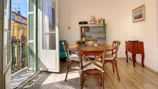 A dining area with a wooden table and chairs, a bookshelf, and a chandelier. - N&J - LAVINIA - Central - Close sea (Niza)