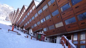 Ein mehrstöckiges Hotel mit modernem architektonischen Design, das große Fenster und ein geneigtes Dach aufweist.