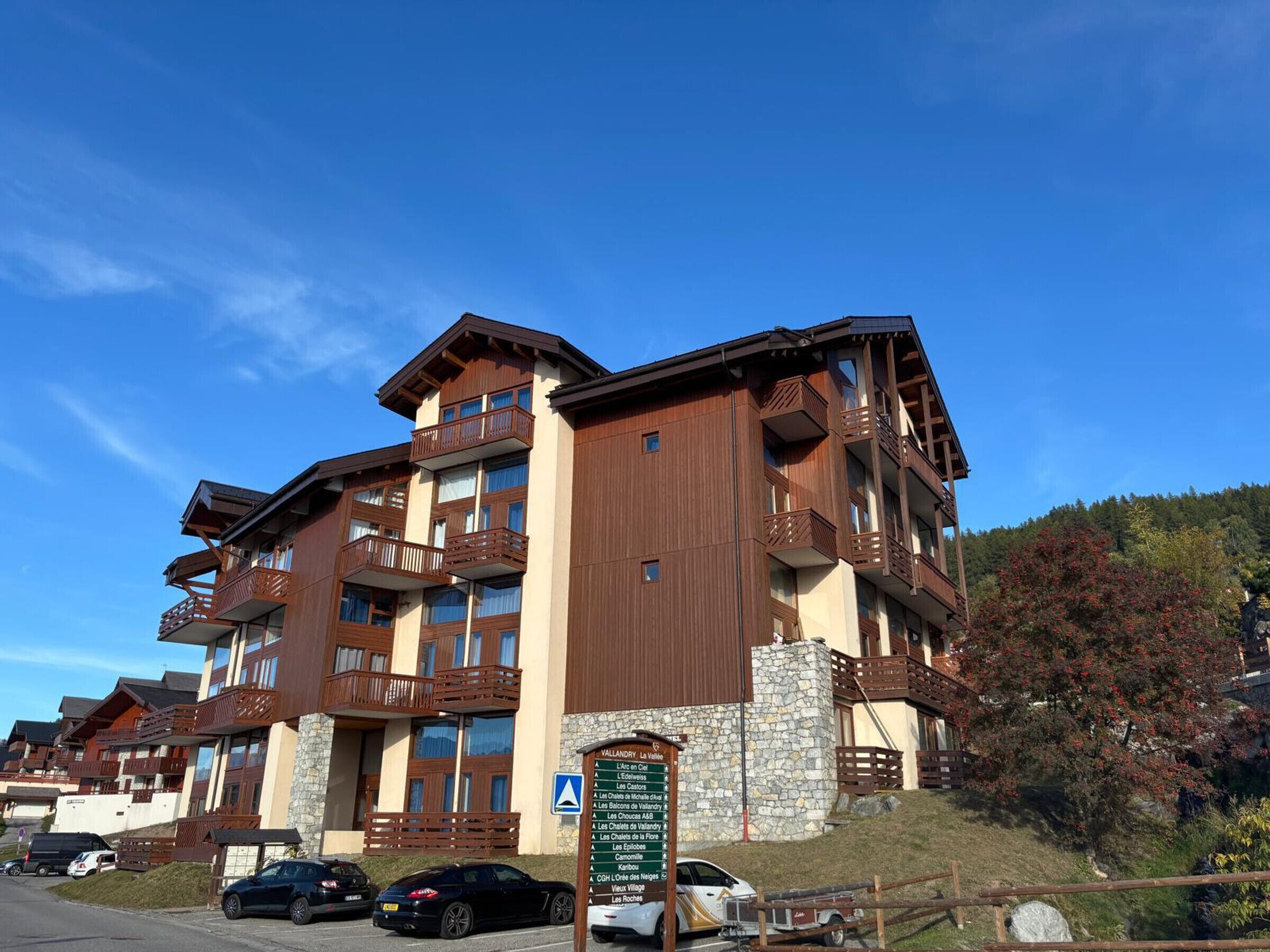 A multi-story hotel with balconies, a stone facade, and a sign indicating amenities.