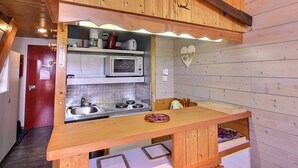 A compact kitchen with wooden cabinets, a microwave, a sink, and a heart-shaped decoration on the wall. - Duplex apartment 3 rooms, 6 pers., in Vallandry, pets allowed (Peisey-Vallandry)