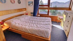 A bedroom with a wooden bed, a dresser, a desk, and a window with a mountain view. - Duplex apartment 3 rooms, 6 pers., in Vallandry, pets allowed (Peisey-Vallandry)