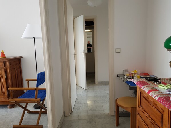 A room with a desk, a chair, a lamp, and a wardrobe.