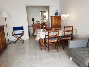 Un espace repas comprenant une table, des chaises, un canapé et une lampe.