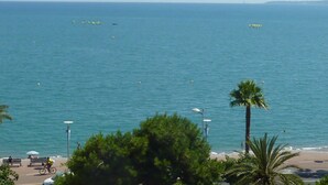 A coastal view with a beach, benches, and a cyclist. - Balcony facing the sea, 3 rooms (76m2), private park DEPARTURE ON SATURDAY EXCLUSIVELY (Cagnes-Sur-Mer)