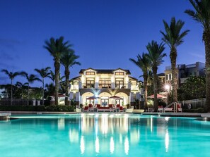 A large, multi-story hotel with a swimming pool in the foreground.