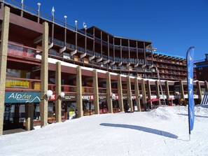 A multi-story building with balconies and a ski rental sign. - Ski-in/ski-out studio for 4 at Arc 2000 (Les Arcs 2000)