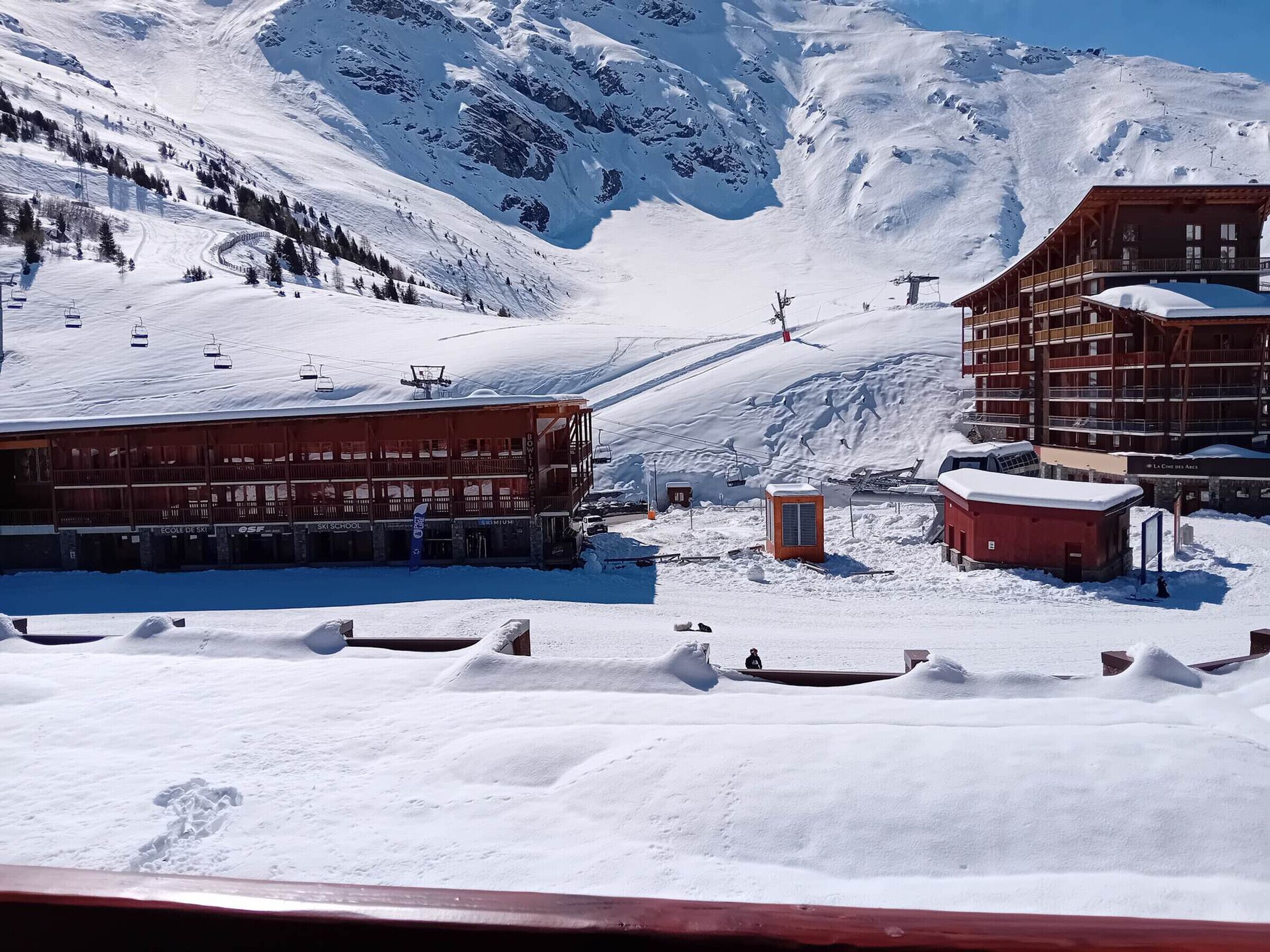 A ski resort with a ski school building, a lift station, and a lodge with a ski lift.
