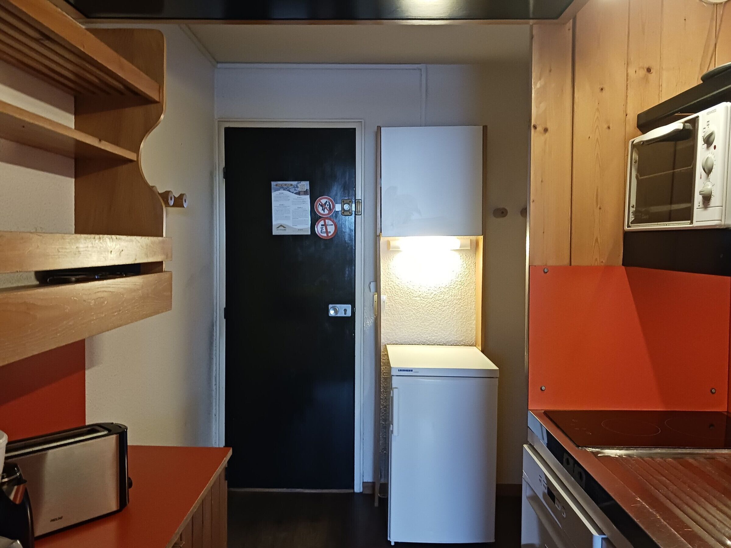 Cocina compacta con refrigerador, tostadora y microondas.