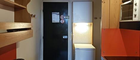 Cocina compacta con refrigerador, tostadora y microondas.