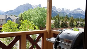 A balcony with a grill and a view of mountains. - Amazing views ! Beautiful 2 bed/2 bath condo.,Free WiFi/Cable. Prime location! (Canmore)