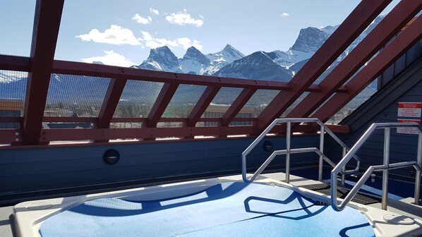 Eine Terrasse mit Metallgeländer, das auf eine gebirgige Landschaft blickt.
