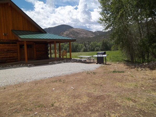 A rustic cabin with a covered porch, a barbecue grill, and a picnic table. - Post Office Ranch Log Cabin - rates subject to change for groups over 2 people (Salida)