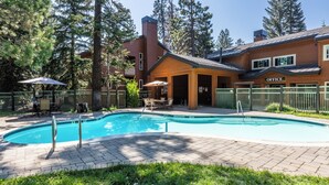 A pool area with a wooden building labeled "OFFICE" in the background, surrounded by trees and a fenced patio. - Walk to Ski & Village, Views Condo, Pool & Spa 315 (Mammoth Lakes)
