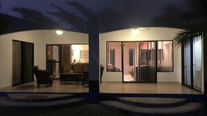 A modern house with a patio area, a dining table, and a sofa.