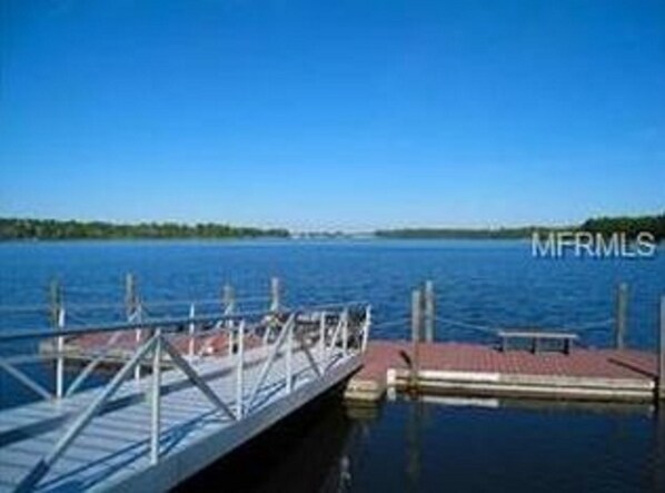 A dock extending into a calm body of water with a clear sky above. - Quiet 2 Bedroom Resort Home (Davenport)