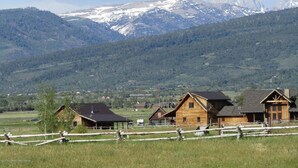 A rural area with wooden cabins and a mountain range in the background.