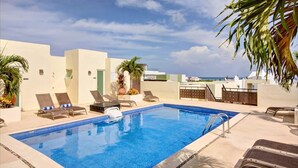A rooftop pool with lounge chairs, palm trees, and a clear sky. - Walk to Beach, Private rooftop, Pool, Parking, M3 (Playa del Carmen)