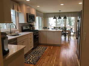 Prepare meals in the well-lit kitchen with a central island, oven, and stainless steel range.