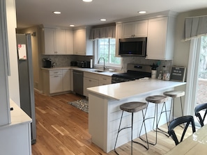 Enjoy cooking in this well-lit kitchen with a central island and stainless steel range hood.
