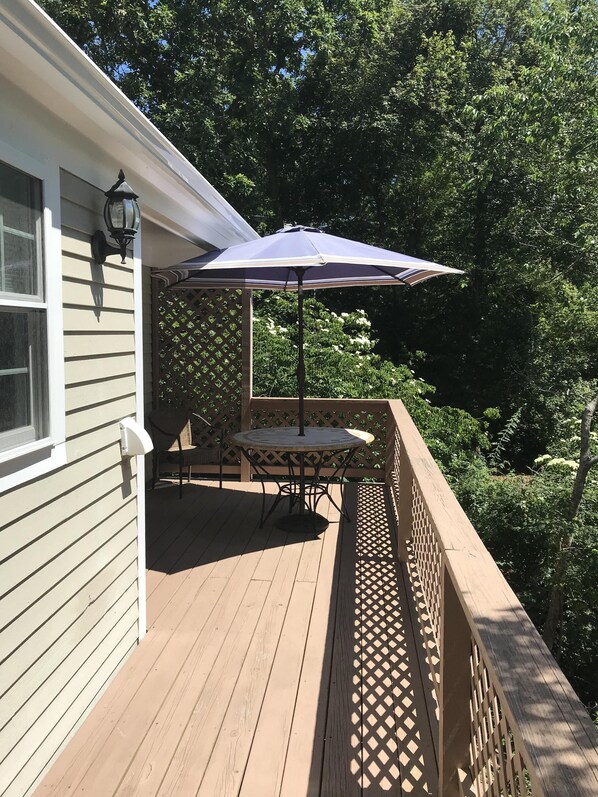 Enjoy a serene outdoor space with a deck, round table, and comfortable chair.