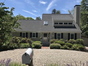 Stunning two-story home with a central entrance, flanked by windows, and a charming porch area.