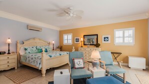 A bedroom with a bed, two nightstands, a chair, a side table, a lamp, a mirror, and a window with blinds.