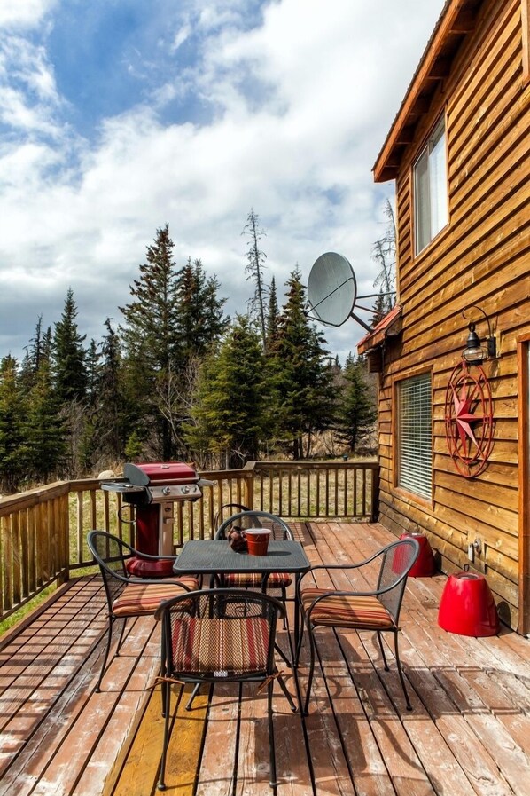 A wooden deck with a table and chairs, a grill, and a satellite dish. - Moose Meadows near Kilcher Homestead in Alaska the Last Frontier (Homer)