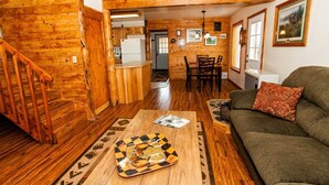 A wooden interior with a staircase, a dining area, and a living room with a sofa and a table. - Moose Meadows near Kilcher Homestead in Alaska the Last Frontier (Homer)