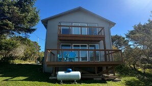 A two-story house with a wooden deck and a covered outdoor seating area. - Starr Creek - Ocean and Creek right outside! (Yachats)
