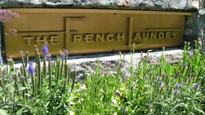 A stone wall with a sign that reads "THE FRENCH LAUNDRY". - Immerse Yourself in Wine Country Long Term Okay (Yountville)