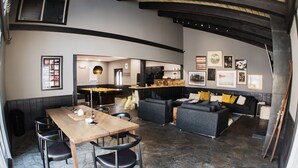 Un interior moderno con comedor, sofá y cocina al fondo.