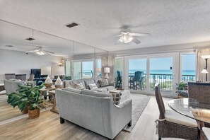 Relax in this stylish living room with a large sofa, dining area, and ocean views.