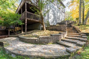 A wooden deck with a stone staircase leading up to a building.