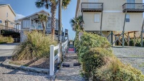 A pathway leading to a private property with a 'PRIVATE PROPERTY' sign, surrounded by vegetation and a building with balconies. - Sassy Seahorse | Pet Friendly + Near Area Fun! (Surf City)