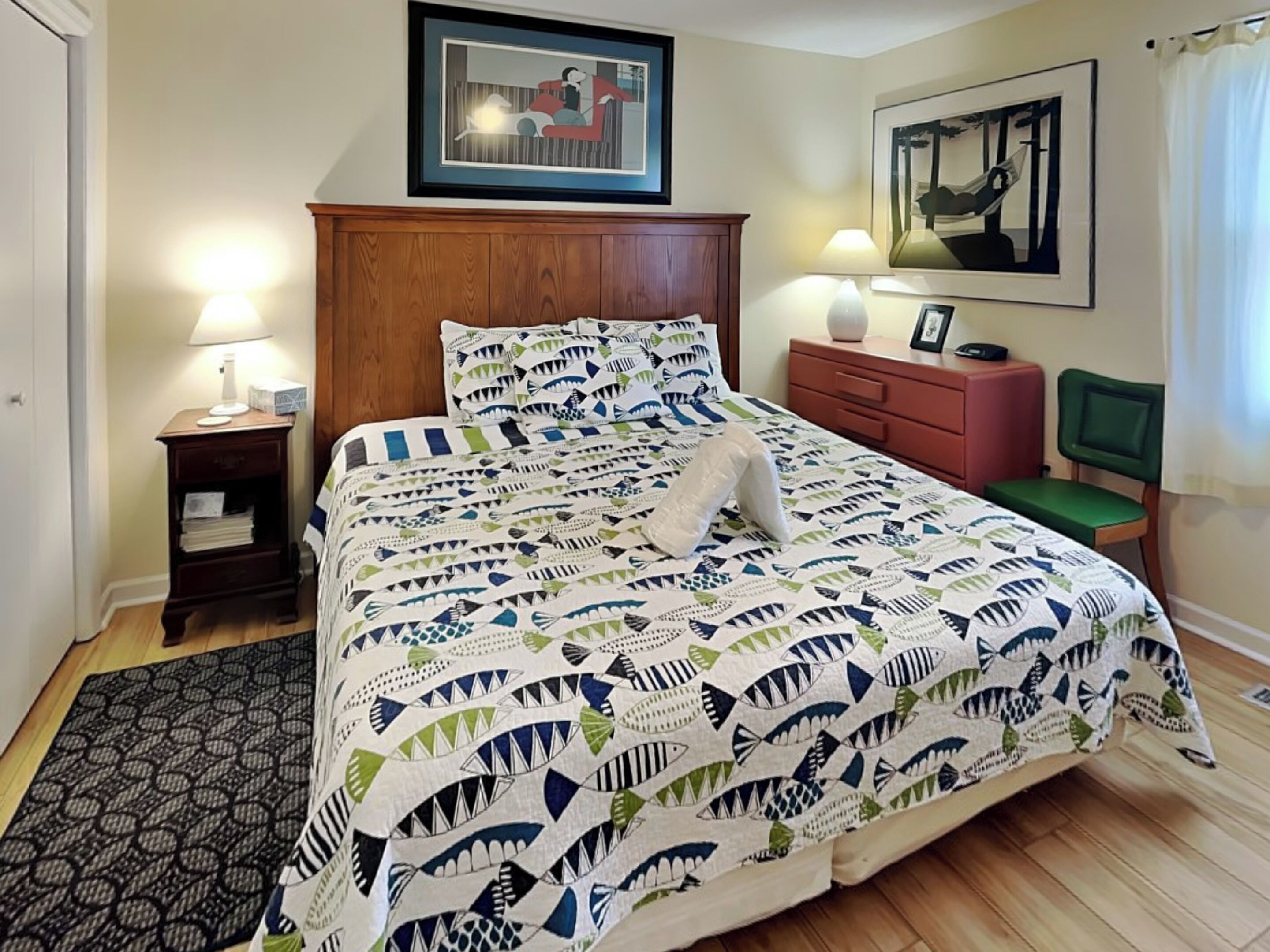 A neatly made bed with a patterned bedspread, a wooden headboard, and two bedside lamps.