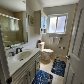 Een badkamer met een wastafel, toilet en raam.