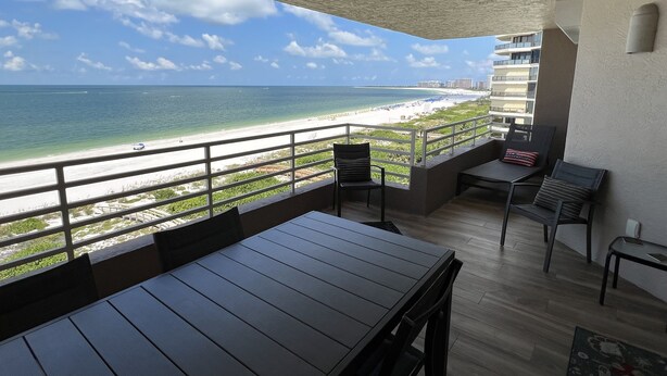 An outdoor balcony with a view of the beach and ocean. - 2 Bedroom, two bath 1500 SF unit with west views of sunsets (Marco Island)