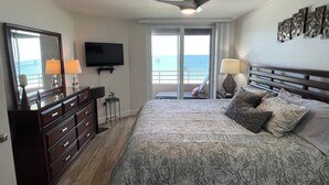 A bedroom with a bed, dresser, TV, ceiling fan, and a view of the ocean through the window. - 2 Bedroom, two bath 1500 SF unit with west views of sunsets (Marco Island)
