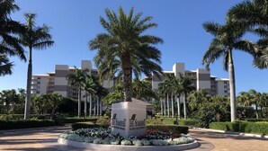 A hotel entrance with a central sign, palm trees, and a paved walkway. - 2 Bedroom, two bath 1500 SF unit with west views of sunsets (Marco Island)