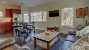 A spacious living area with a dining table, sofa, and a kitchen in the background. - Surfsup - Downtown, River View, A/C, Stay for a Month! Great Rates! (Hood River)