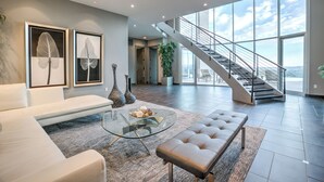 A spacious living area with a modern staircase, large windows, and a minimalist design. - Scottsdale Manor - 9BR Estate w/ Infinity Pool, Theater & Mountain Views (Phoenix)