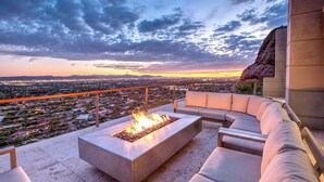 A rooftop terrace with a fire feature, outdoor seating, and a city view at sunset. - Scottsdale Manor - 9BR Estate w/ Infinity Pool, Theater & Mountain Views (Phoenix)