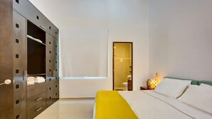 A hotel room with a bed, a wardrobe, and a bathroom visible through an open door. - 2BR, Central, Sleeps 6, Garage, Roof Pool, A306 (Playa del Carmen)