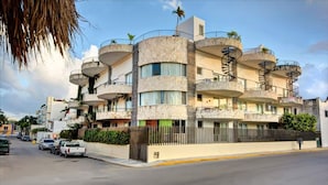 A multi-story building with balconies, a spiral staircase, and a gated entrance. - 2BR, Central, Sleeps 6, Garage, Roof Pool, A306 (Playa del Carmen)