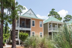 A two-story house with a green roof, a balcony, and a porch.