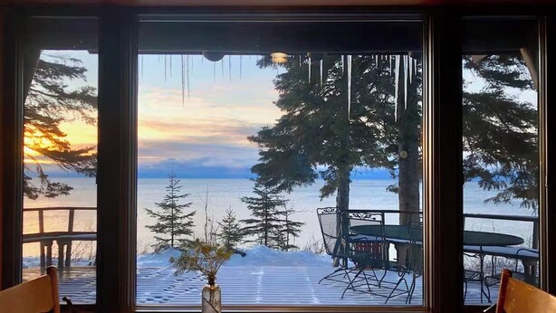 Comedor con vista a un paisaje nevado y un atardecer.